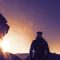 pexels photo 1109881 1109881 Silhouette of a hiker climbing up a mountain trail at sunrise with sun flares and mountains in the background.